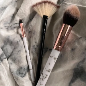 Sminkborstar 3 st - Säljer tre stycken sminkborstar!Två har vita handtag med marmormönster och roséguldsdetaljer, den tredje har svart handtag. Perfekta för bas, highlight och ögonskuggor.⭐️