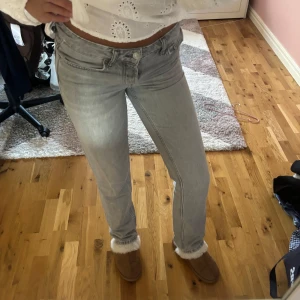 Grå jeans  - Säljer ett par ljusgrå lågmidjade jeans från 157 i modellen Icon. De har klassisk femficksdesign, raka ben och normal passform. Jeansen är i mjukt bomullsmaterial och har snygga detaljer med dubbla knappar i midjan. Perfekta för dig som gillar stilrena och enkla jeans. Ganska urtvättade så de är ljusare än hur de vanligtvis är har ett litet hål på bakfickan men inget som gör så att huden syns
