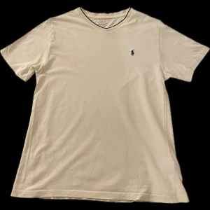 Vit Polo Ralph Lauren t-shirt - Säljer en snygg vit Polo Ralph Lauren t-shirt! Den är i storlek 14-16 (164-170). I nacken är det ett litet hål som inte syns under användning, hör av er om ni har några funderingar😁