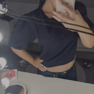 Mörkblå croppad tröja Gina Tricot - Snygg mörkblå croppad tröja från Gina Tricot med puffiga korta ärmar och rund hals. Tröjan har ribbade muddar vid hals och nederkant, vilket ger en chill och trendig vibe. Perfekt att matcha med jeans eller kjol för en cool look.