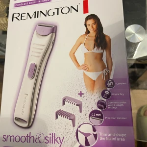 Remington bikini trimmer lila/vit - Remington bikini trimmer i vit och lila med två lila kammar för olika längder. Sladdlös och kan användas både torrt och i duschen. Kommer med laddare och en vit förvaringspåse i tyg. Perfekt för att forma bikinilinjen.