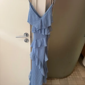 Ljusblå långklänning med volanger - Säljer denna fina ljusblå  Zara klänningen då den var för liten för mig! Oanvänd och prislappen sitter kvar. 