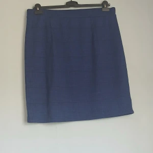 Elegant mörkblå kjol från Cellbes – stl 46/48 - Säljer en elegant mörkblå kjol från Cellbes, storlek 46/48. Kjolen har ett klassiskt rutmönster i diskret hundtandsstil och är sydd i ett mjukt, följsamt material med lätt stretch för hög komfort. Modellen är rak och knälång, vilket gör den perfekt både till kontoret och till vardags.  Skick: Mycket fint skick, knappt använd. Färg: Mörkblå Mönster: Rutigt/hundtand Passform: Bekväm och figursmickrande  Perfekt för dig som söker en tidlös och mångsidig kjol att använda året runt. 