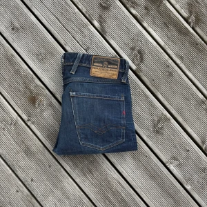 Blå Replay Anbass jeans slim fit - Snygga blå jeans från Replay med klassisk femficksdesign och raka ben. Jeansen har läderpatch bak i midjan och coola kontrastsömmar. Tillverkade i slitstarkt denim med diskret tvättad look. Perfekta för dig som gillar en tidlös och clean stil. Kom gärna med frågor!🙌 W31 L32