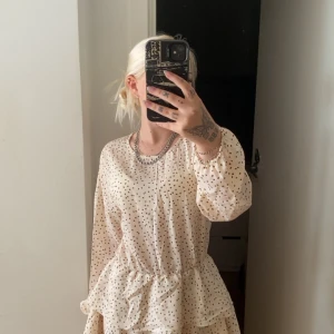 Prickig ljus klänning med volang - Supersöt ljus klänning som tyvärr inte kommer till användning. använd bara en gång.