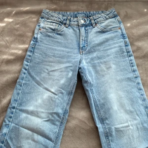 Ljusblå jeans från Kappahl, stl 158 - Snygga ljusblå jeans från Kappahl i rak modell, bakfickor med lock och silverfärgade knappar. Perfekta till som vill ha en avslappnad stil. Jeansen har varit en stor favorit, men tyvärr passar dom inte längre. Byxorna har inte några direkta skador. 🩷