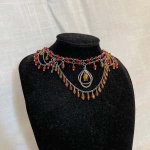 Handgjort halsband  - Röda pärlor och orangea droppar med detaljer i rostfritt stål. Hänget i mitten är köpt secondhand <3 