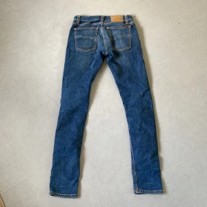 Blå jeans från Nudie Jeans, 27/32 - Ett par snygga blå jeans från Nudie, knappt använda. Modell: straight/regular. Storleken är 27 men skulle själv säga att midjemåttet funkar som 28. Priset kan diskuteras. Hör av om frågor.