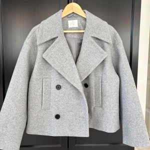 Grå kappa - Snygg grå skepparkavaj från Primark med bred krage och dubbelknäppning framtill. Jackan har raka, långa ärmar och två fickor framtill. Den är perfekt till hösten. Den är aldrig använd och är i jättebra skick.💓