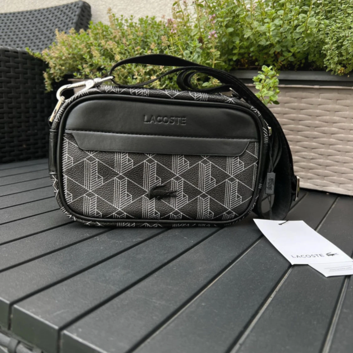 Svart axelväska från Lacoste med mönster