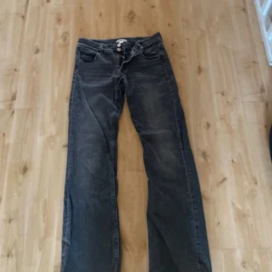 Mörkgrå bootcut jeans Gina Tricot - Snygga mörkgrå jeans från Gina Tricot i bootcut-modell. Jeansen har klassisk femficksdesign, dubbla silverknappar och dragkedja. Tillverkade i jeansmaterial med en cool tvättad look och raka ben som släpper ut nertill.
