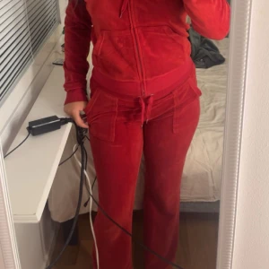  Juicy byxor  - Säljer ett par röda mjukisbyxor i mjuk velour med bred resår i midjan och snörning. Byxorna har raka ben, fickor framtill och en chill vibe. Perfekta för dig som gillar comfy och snyggt på samma gång. De ända fel med dom är snöret så finns de  en metall på. Alla har åkt av!