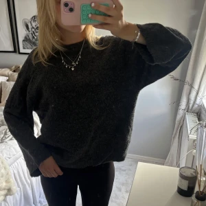 Mörkgrå stickad tröja  - Mysig mörkgrå stickad lite tunnare  tröja med avslappnad, loose passform och långa ärmar. 