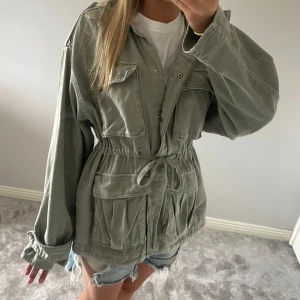 Grön jeansjacka med snörning i midjan - Snygg jeansjacka som är justerbar i midjan. Jackan är oversize och är i storlek M, passar mellan XS-M