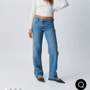 ljusblå raka jeans -  jeans i ljusblå tvätt med rak passform och låg midja. Jeansen har fem fickor, knappgylf och är tillverkade i slitstarkt bomullsjeans. Perfekta för en avslappnad och tidlös look. Passar både S och M