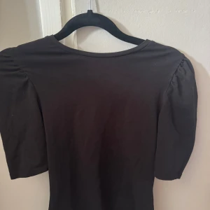Svart topp med puffärm från ONLY - Söt svart topp från ONLY med puffiga korta ärmar och rund halsringning. Enkel och stilren design som passar till många olika looks. Tröjan är endast testad och är därför i mycket bra skick!💞