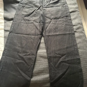 Svarta linnebyxor med resårmidja - Snygga svarta linnebyxor med avslappnad passform och resår i midjan. Byxorna har raka ben, sidfickor och två bakfickor.