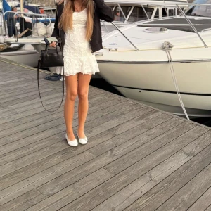 Vit spetsklänning med volang - Supersöt vit klänning med blommig spets och volang upptill & nertill. Klänningen har en figurnära. Perfekt för sommaren. Använd 1 gång! PRIS KAN DISKUTERAS 