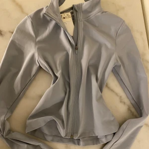 Ljusblå sportig vindjacka med dragkedja Softmove blå H&M - Snygg ljusblå vindjacka med hel dragkedja framtill och hög krage. Jackan har en slim passform och är tillverkad i ett mjukt, stretchigt syntetmaterial som passar perfekt för träning eller chill. Långärmad modell med stilren look.