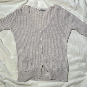 Tunn kofta - En tunn, beige kofta från Gina Tricot med små vita knappar. Etiketten säger storlek L men jag har vanligtvis XS och den passar perfekt.