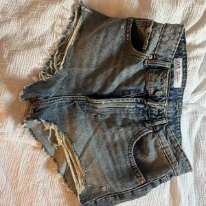 Blå jeansshorts med fransar från Zara - Säljer ett par blå jeansshorts från Zara använda endast fåtal gånger. Säljer då dem blivit för små.