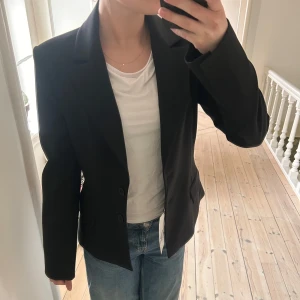 Svart kavaj - Super snygg svart kavaj med normal passform. Perfekt för en stilren look. Kavajen har långa ärmar och knäppning framtill. Perfekt till både fest och vardag!🤩helt ny med prislapp kvar! Säljer då den tyvärr inte kommit till användning! 