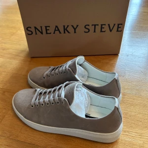 Grå sneakers från Sneaky Steve - Snygga grå sneakers från Sneaky Steve i mocka. Endast använda ett par gånger, så som nya. Storlek: 40. Skriv för fler bilder eller funderingar.