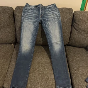 Blå jeansbyxor - Snygga blå jeansbyxor med en lätt tvättad look. De har en klassisk femficksdesign och en dragkedja framtill. Perfekta för en avslappnad stil.