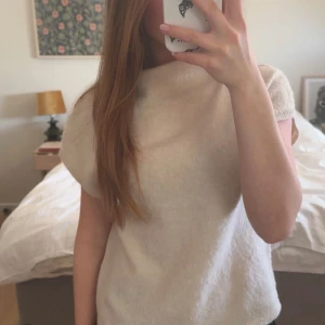 Beige stickad topp - Säljer min fina stickade topp med korta ärmar och lite högre krage. Bara andvänd ett fåtal gånger och därmed i fint skick! Hör av dig vid frågor eller fler bilder💗💕
