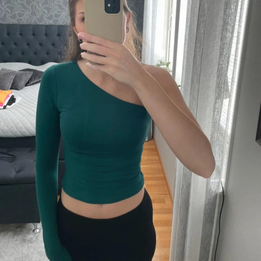 Grön one shoulder-topp från H&M i strl XS. Använd en gång.. Yläosat.