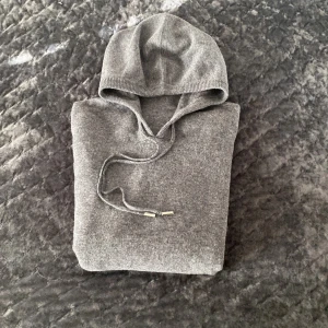 Kashmir/Merino Hoodie - Tja! Säljer nu denna HELT NYA äkta kashmir Hoodien! As fet mörkgrå färg o riktigt skön, snörena går att ändra i längd och det går även att ta bort metallbitarna i slutet på de för en Soft Goat look! Storlek M och passar tts (175-185) Jag är 185 och väger 68 och den passar helt perfekt! Pris kan diskuteras. Hör av dig vid minsta fundering!🌟