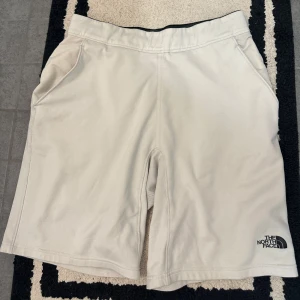 Shorts The North Face - Säljer ett par vita shorts från The North Face. De har en normal passform och är tillverkade i ett bekvämt material. Shortsen har fickor på sidorna och en diskret logga på benet.