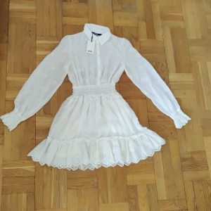 Vit klänning  - Vit klänning från Gina Tricot säljes. Storlek XS, helt oanvänd med prislappen kvar. 