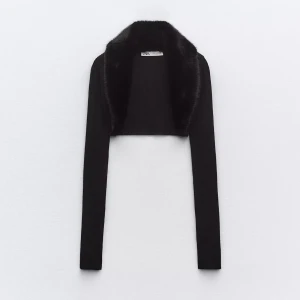 Stickad svart bolero med fuskpäls från Zara  - Snygg svart stickad bolero från Zara med långärmade ärmar och fuskpälskrage. Aldrig använd, prislapp finns kvar. Storlek M