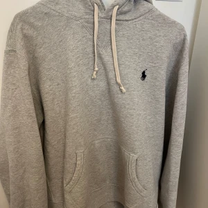 Grå hoodie från Ralph Lauren - Säljer en stilren grå hoodie från Ralph Lauren med klassisk logga på bröstet. Är i väldigt bra skick och bara använts ett fåtal gånger. Priset kan diskuteras vid snabb affär! 