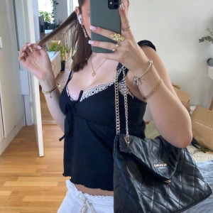 Svart quiltad axelväska från Valentino - Snygg svart axelväska från Valentino i quiltat skinn med guldfärgade kedjedetaljer. Väskan har en elegant design med en praktisk storlek för alla dina nödvändigheter. Perfekt för att ge din outfit en lyxig touch. Har några få användnings tecken men inget man tänker på!