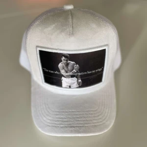 Vit Valvet keps med citat och bild - Snygg vit Valvet keps med ett svartvitt tryck av en boxare och citatet 'The man who has no imagination has no wings'. Kepsen har en klassisk design med böjd skärm 