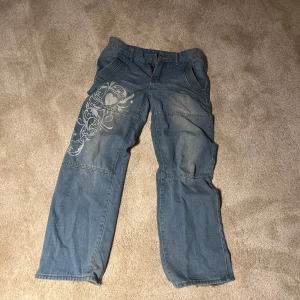 Baggy jeans med mönster - Säljer ett par baggyjeans med ett hjärtmönster på. Tyvärr så har inte jeansen någon sorts storleksguide eller märke men skulle säga att det passar alla som har runt storlek 30? Detta är dock ingen självklarhet utan bara från personliga tankar❤️de är även rätt långa i benen