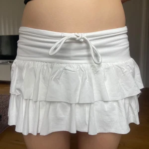 Vit low waist volangkjol - Säljer en söt volangkjol, lågmidjad/low waist. Från okänt märke men tidigare köpt på plick! Inga täcken på användning, som ny. Midjemått 36, längd 27 💘