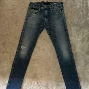 Blå jeans från Replay - Snygga blå jeans från Replay med en sliten look och diskreta slitningar.  Modellen heter Replay anbass