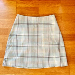 Pastel grön rutig kjol - Fin rutig kjol från Monki. Passar till sommaren! Midjan är 32 cm.