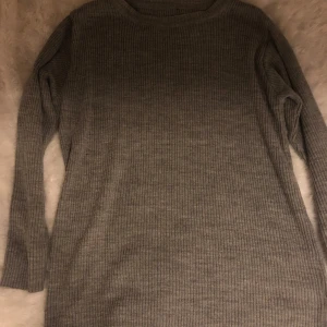 Grå ribbad tröja - Säljer en stilren grå ribbad tröja med långa ärmar. Perfekt för kyligare dagar och enkel att matcha med olika outfits.