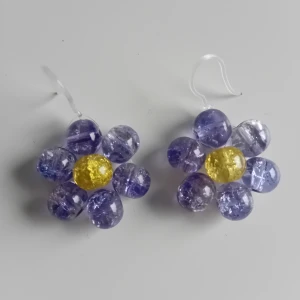 Örhängen blomma - Egentillverkade örhängen gjorda i krackelerar glaspärlor. Färg är blå/lila längd ca 2.5cm långa. Öronkroken är gjord i plast. Aldrig använda 