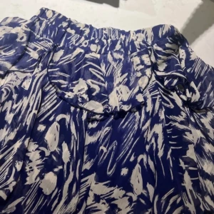 Zara minikjol - Snygg blå och vit kjol med abstrakt mönster och volangdetaljer. Perfekt för att ge en färgklick till din outfit. Resår i midjan för bekväm passform. 