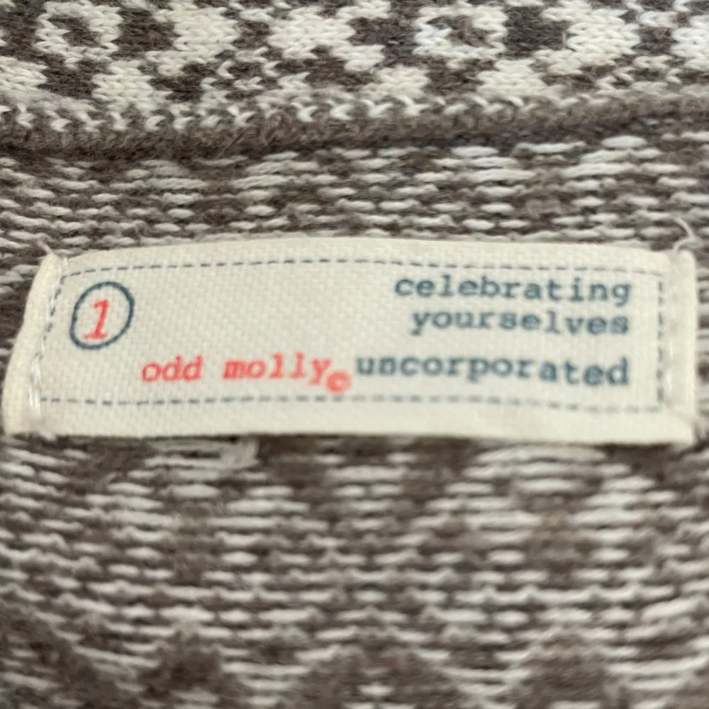 Säljer en snygg mönstrad kofta från Odd Molly i beige och brun. Koftan har ett fint mönster och knyts med ett svart band framtill. Perfekt för att ge din outfit en unik touch.. Neuletakit & Villapaidat.