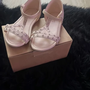 Vita sandaler från Zara - Söta vita sandaler från Zara med dekorativa diamanter och justerbart spänne runt ankeln. Perfekta för sommarens alla äventyr. Sandalerna har en bekväm passform och är lätta att ta på och av.