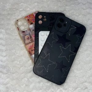 Tre mobilskal med olika mönster - Säljer tre unika mobilskal. Ett svart skal med stjärnmönster, ett svart skal med en pussmunnar och ett transparent skal med collage av söta kattbilder. Perfekt för att ge din mobil en personlig touch!