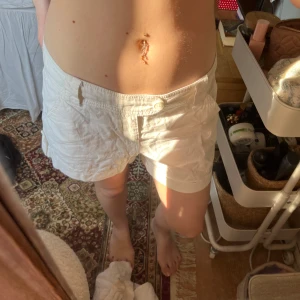 Vita shorts från Authentic köpta på Vinted  - Säljer ett par vita shorts från Authentic. De har en knapp och dragkedja framtill samt fickor på sidorna och bak. Perfekta för varma dagar! De är lågmidjade och jätte bekväma verkligen, Jag har st S och dom passar hyfsat de är lite hängiga där bak så skulle säga S/M beroende på hur man vill de ska sitta!