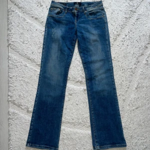 Blå jeans LTB - Blåa valerie jeans från LTB med lite slitningar, storlek 29/32 och passar S/M. De är lågmidjade och utsvängda