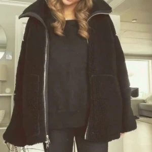 Svart teddyjacka med dragkedja från arket - Mysig svart slutsåld teddyjacka från arket med dragkedja framtill och hög krage. Jackan har en oversized passform och stora fickor framtill, jackan är använd max 10 gånger och är i nyskick 💞 nypris ligger på 1500kr. Pris går att diskutera vid snabb affär !